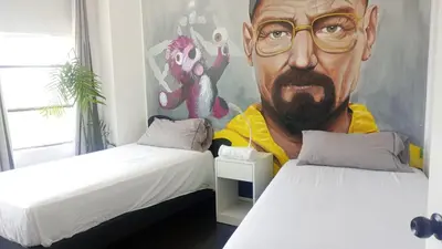 a room with two beds with a painting of a man at PintoHome in Lima