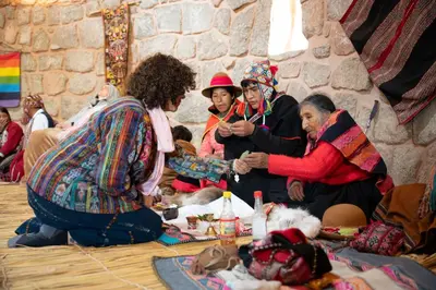 a group of women sitting around a table with food at Pachamama Hampina Wasi Ancestral Center in Urubamba