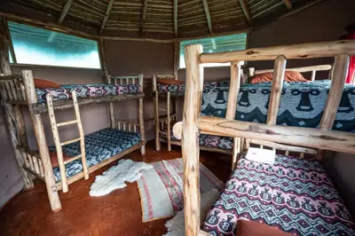 a room with three bunk beds in a house at Pachamama Hampina Wasi Ancestral Center in Urubamba
