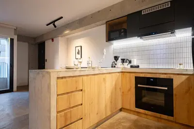 a kitchen with wooden cabinets and black appliances at MMXX Apartments by Vibrant in Lima
