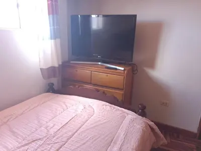 a bedroom with a bed and a flat screen tv at El despertar del inka in Cusco