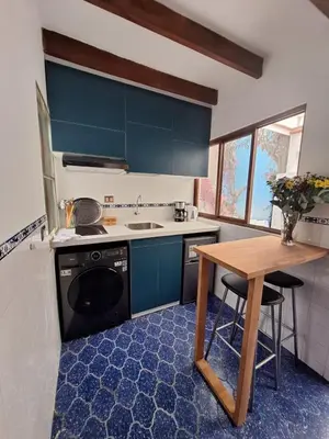 a kitchen with blue cabinets and a wooden table at Historic Quinta, Heart of Miraflores, 2 Bedroom Apartment in Lima