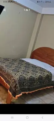 a bed with a comforter on top of it at Hostal Qori in Urubamba
