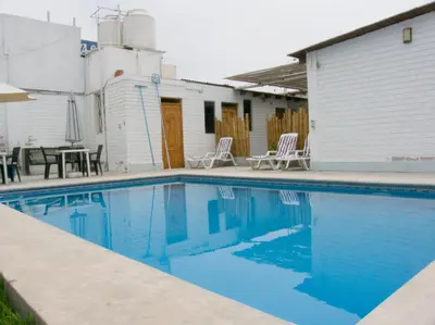 a swimming pool with two chairs and a table at Apartment with Beach Exit 201 in Punta Negra
