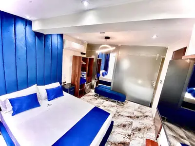 a bedroom with a bed and a blue wall at Hotel BlueThree Chancay in Chancay