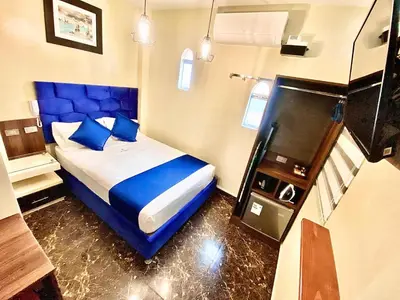 a bedroom with a blue bed with blue pillows at Hotel BlueThree Chancay in Chancay