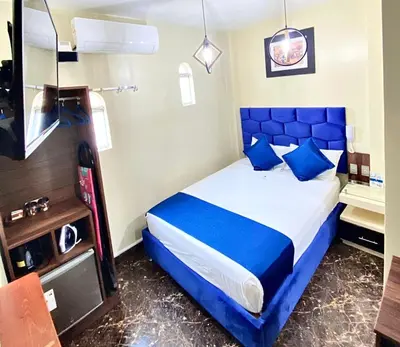 a bedroom with a blue bed with blue pillows at Hotel BlueThree Chancay in Chancay