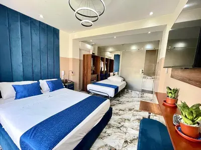 a hotel room with two beds and a desk and a room at Hotel BlueThree Chancay in Chancay