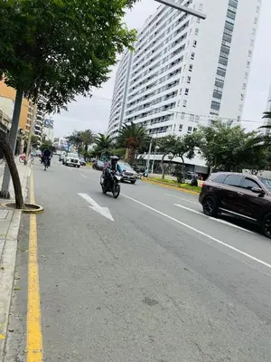 a person riding a motorcycle down a city street at Apto/ cama king2 en el centro Miraflores in Lima