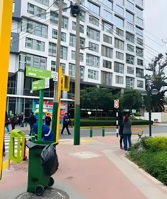 a man sitting on a trash can next to a street sign at Habitación Acogedora con Baño Privado y Entrada Propia en Miraflores in Lima