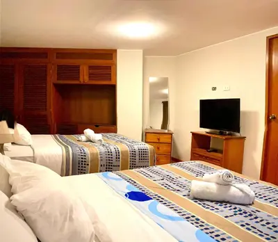 a hotel room with two beds and a flat screen tv at Suite Independiente con Baño Privado – Miraflore in Lima