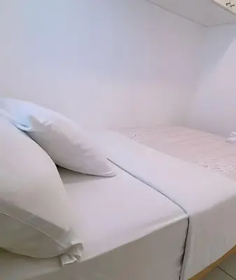 a white bed with two pillows on it at SM3 Habitación pequeña con baño privado/Miraflores in Lima