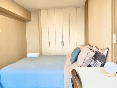 a bedroom with a blue bed and white cabinets at Apartamento con vista a San Isidro in Lima