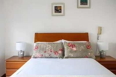 a bedroom with a bed with pillows and two lamps at Central Bloom Miraflores in Lima