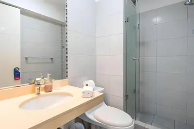a bathroom with a toilet and a sink and a shower at Central Bloom Miraflores in Lima
