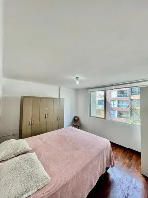 a bedroom with a pink bed and a window at Apartment with 3 bedrooms near the sea in Miraflores in Lima