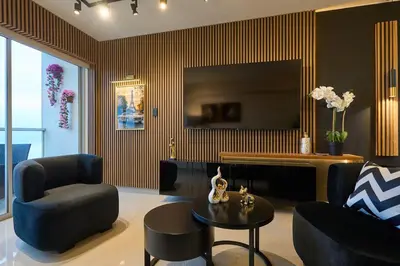 a living room with a tv and a chair and a table at Apartamento moderno cerca del Parque Wallenberg in Lima