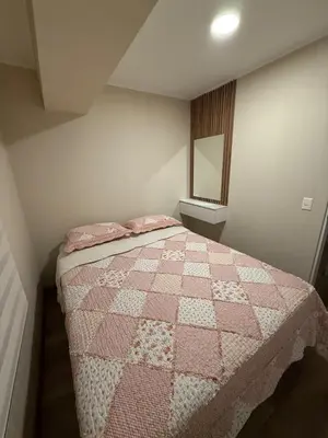 a bedroom with a pink and white quilt on a bed at Apartment in Victoria in Lima