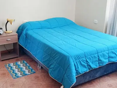 a blue bed with a blue comforter on it in a bedroom at bambanhouse in Cusco