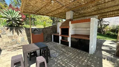 a outdoor grill with a table and chairs on a patio at Casa Huerta Vista Bonita in Canta