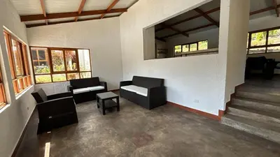a living room with two chairs and a table at Casa Huerta Vista Bonita in Canta