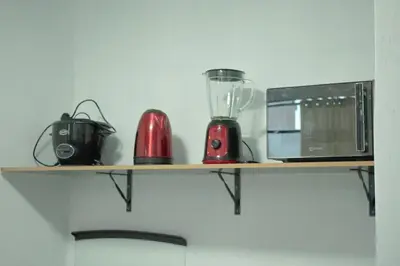 a shelf with a blender and a microwave on it at Mini departamento con cochera in Ayacucho