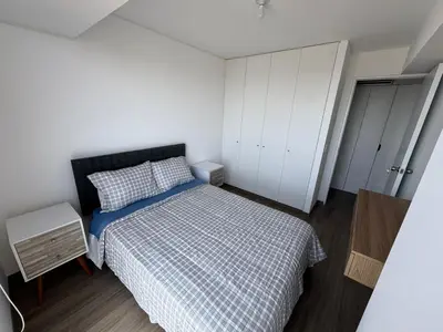 a small bedroom with a bed and a white cabinet at Cozy Room in Miraflores with rooftop pool in Lima