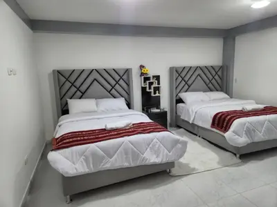 two beds in a bedroom with white walls at Camino del Sol in Cusco