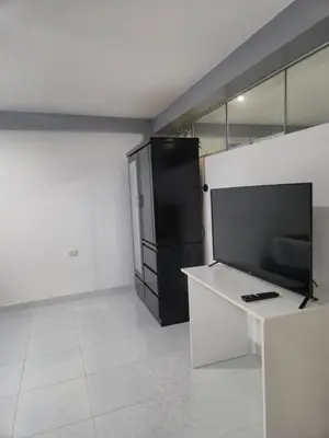 a living room with a tv and a black refrigerator at Camino del Sol in Cusco