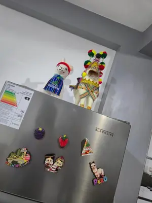a refrigerator with magnets and figurines on top of it at Camino del Sol in Cusco