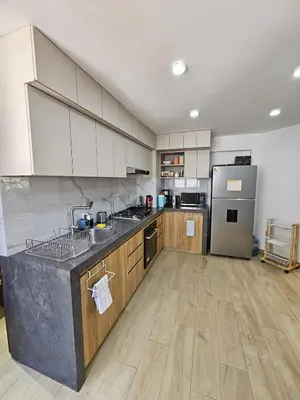 a kitchen with white cabinets and a stainless steel refrigerator at Apartamento renovado en Miraflores in Lima