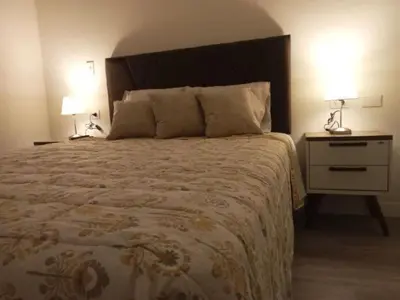 a bedroom with a bed and a night stand with two lamps at Edificio The sight Barranco vista al mar in Lima