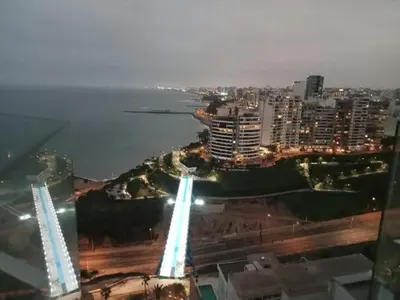 a view of a city at night with the ocean at Edificio The sight Barranco vista al mar in Lima