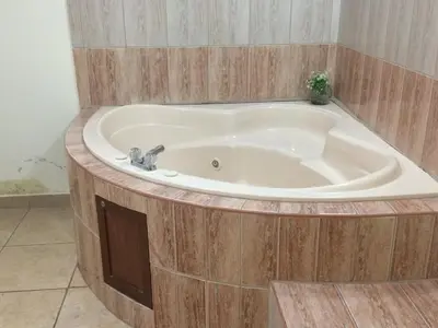 a bath tub with a sink in a room at Hotel Misky Samay in Ayacucho