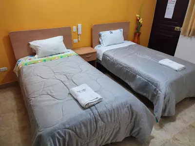two beds sitting next to each other in a room at Hotel Misky Samay in Ayacucho