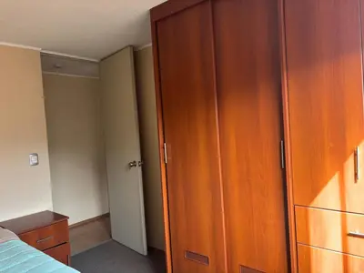 a bedroom with a wooden wardrobe and a bed at Three-bedroom apartment in San Miguel in Lima