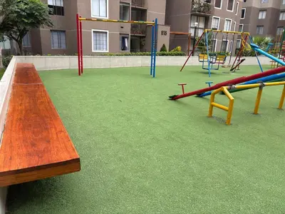 an empty playground with a bench and swings at Three-bedroom apartment in San Miguel in Lima