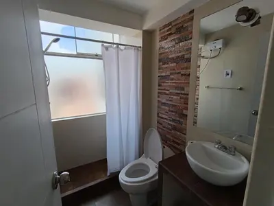 a bathroom with a toilet and a sink and a window at Apartamento en Cusco III in Cusco