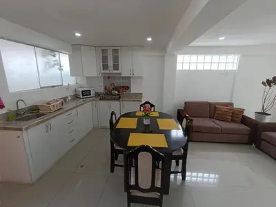 a kitchen and living room with a table and a couch at Apartamento en Cusco III in Cusco