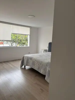a white bedroom with a bed and a window at Casa amplia y acogedora, en Miraflores in Lima