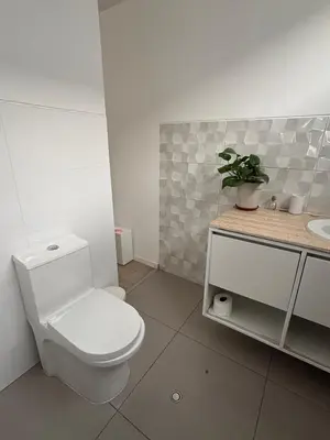 a white bathroom with a toilet and a sink at Casa amplia y acogedora, en Miraflores in Lima