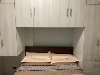 a bed in a room with white cabinets at Casa de Moño - Moderno apartamento cerca a Aeropuerto y Terminal Terrestre in Lima