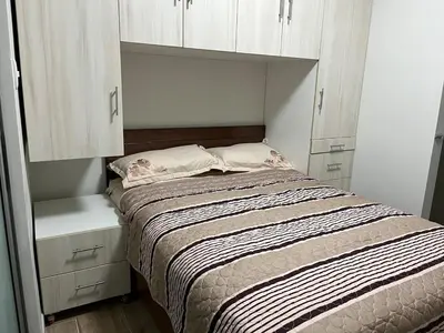 a small bedroom with a bed and white cabinets at Casa de Moño - Moderno apartamento cerca a Aeropuerto y Terminal Terrestre in Lima