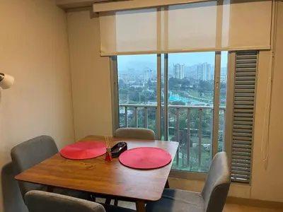 a dining room table with red chairs and a large window at Magical View Parque de las Aguas, central apartment in Lima