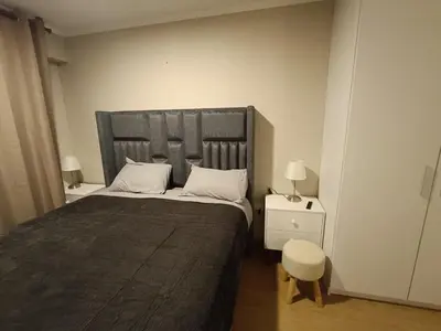 a bedroom with a large bed and two night stands at Apartment overlooking the water park in Lima