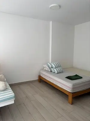 a bedroom with a bed and a couch at Beach house - Alto Bujama Condominium in Asia