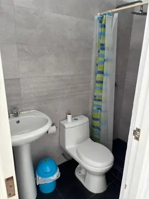 a bathroom with a white toilet and a sink at Beach house - Alto Bujama Condominium in Asia