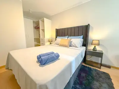 a bedroom with a large bed with blue towels on it at Modern XXL Apartment in San Miguel in Lima