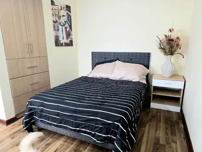 a bedroom with a bed with a black and white striped blanket at Barranco sea in Lima