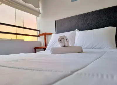 a stuffed animal is sitting on a bed at E Tourist Zone Wifi Pro 2 Smart TV 3B 1206 in Lima